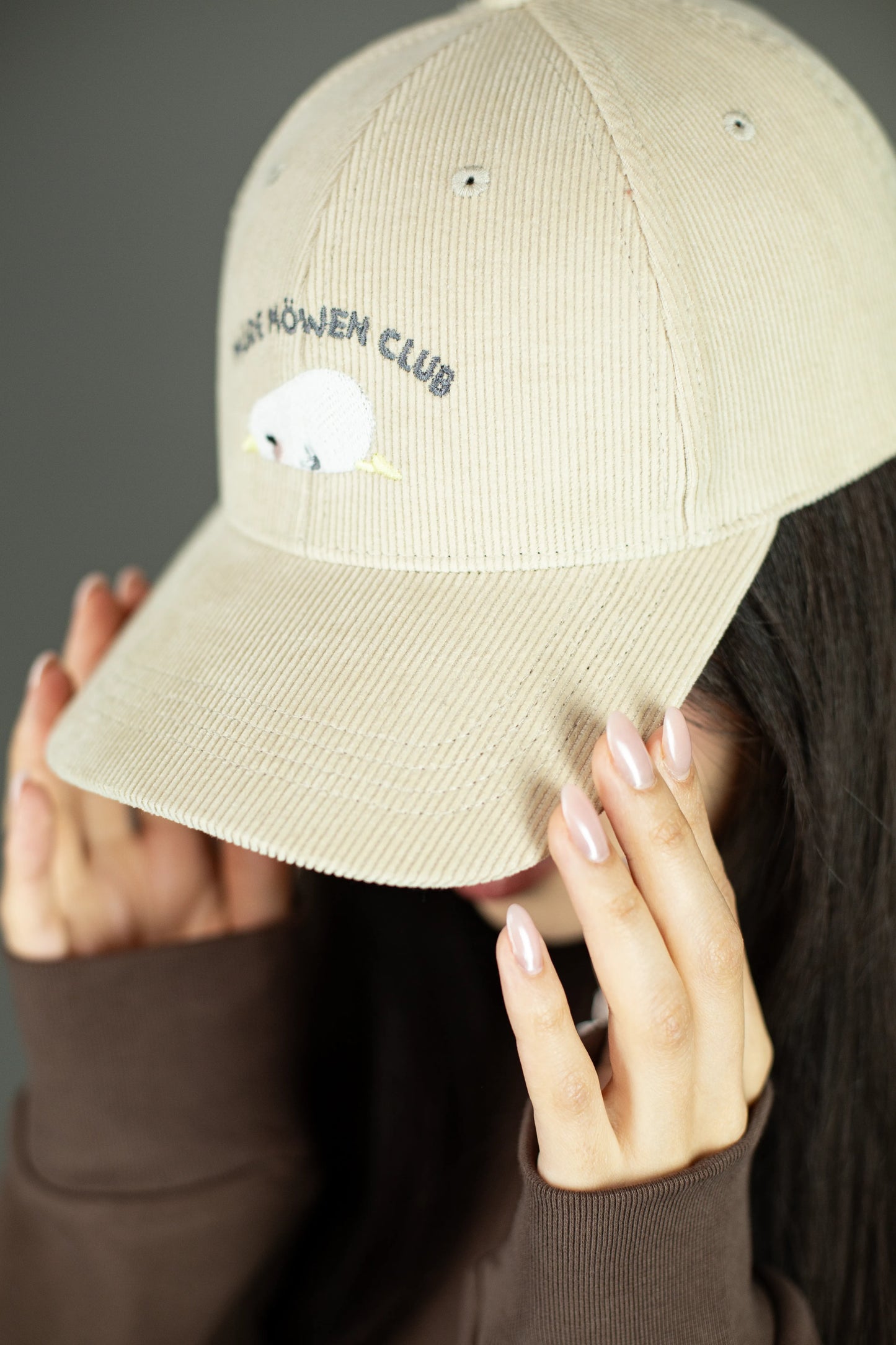 Detailaufnahme der beigefarbenen Cord-Cap mit sichtbarer Stickerei „MÜDE MÖWEN CLUB“ und schlafender Möwe mit gelbem Schnabel. Der Fokus liegt auf der feinen Cordstruktur und der gestickten Oberfläche.