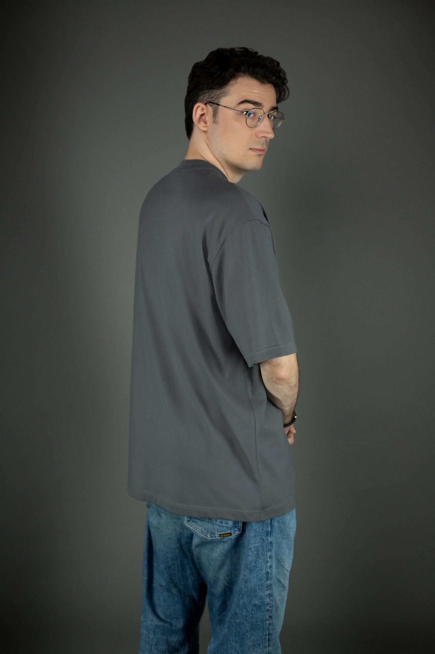 Rückansicht des grauen Oversized-T-Shirts. Das Design ist schlicht und ohne Rückendruck, mit glatter Stoffstruktur und weitem Schnitt.